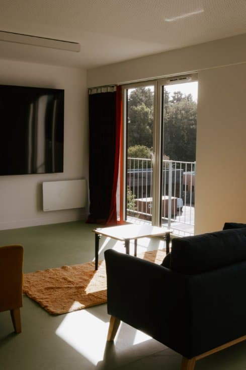 Salle de repos de la Résidence Rosolino avec canapé et écran TV