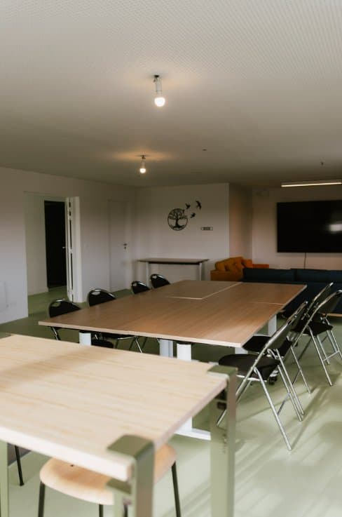 Salle de travail de la Résidence Rosolino avec tables et chaises, espace commun pour étudiants